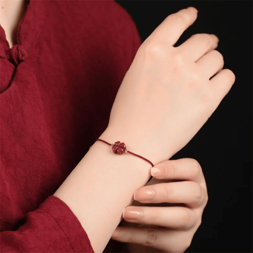 Bracelet Porte Bonheur de couleur rouge vin portée par une femme