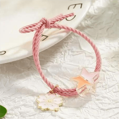 gros plan du Bracelet BFF rose d'un pendentif d'une fleur cherry blossom